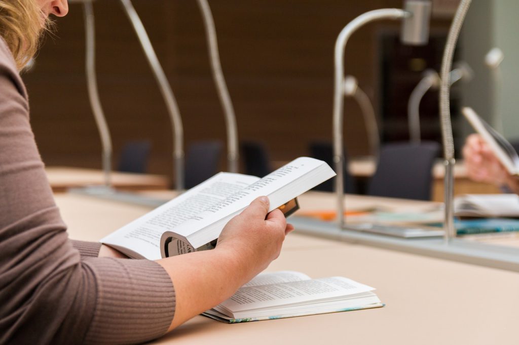 En elev sitter och läser i en bok